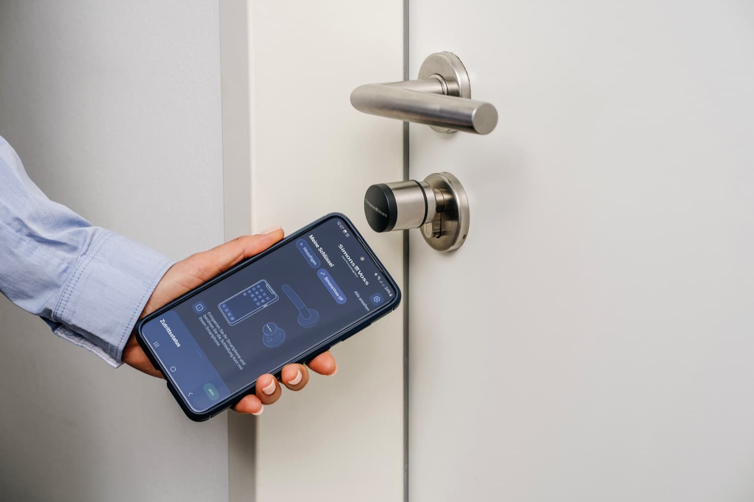 Eine Tür wird mit dem Smartphone geöffnet – digitaler Schließzylinder